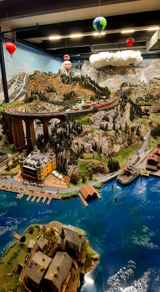 Miniature Alpine landscape with mountains, trees and colourful hot-air balloons at Miniatur Wunderland in Hamburg.