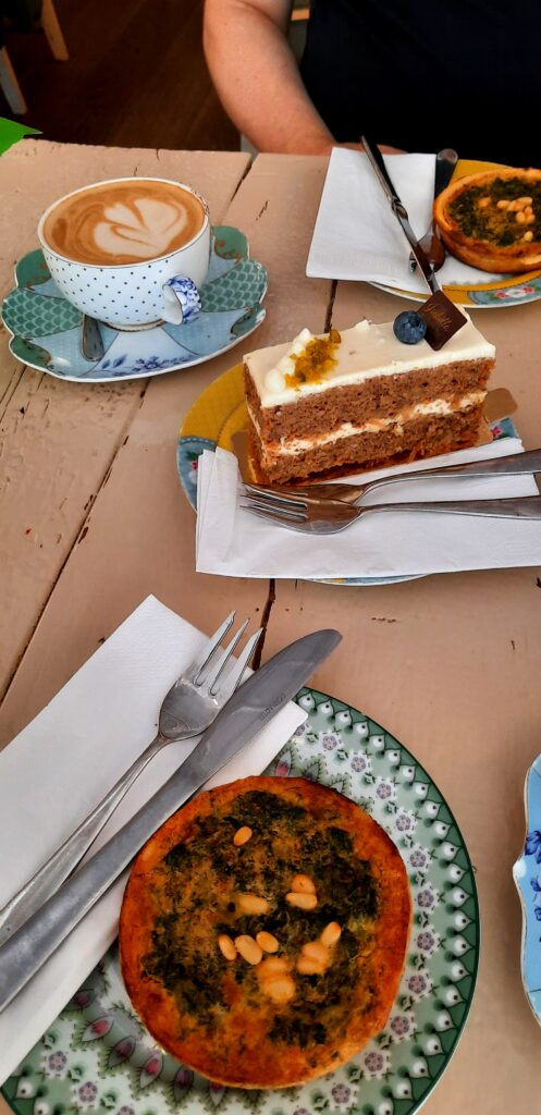 Coffee, a slice of layered cake and two savoury tarts served at Isabella Glutenfreie Pâtisserie in Hamburg.