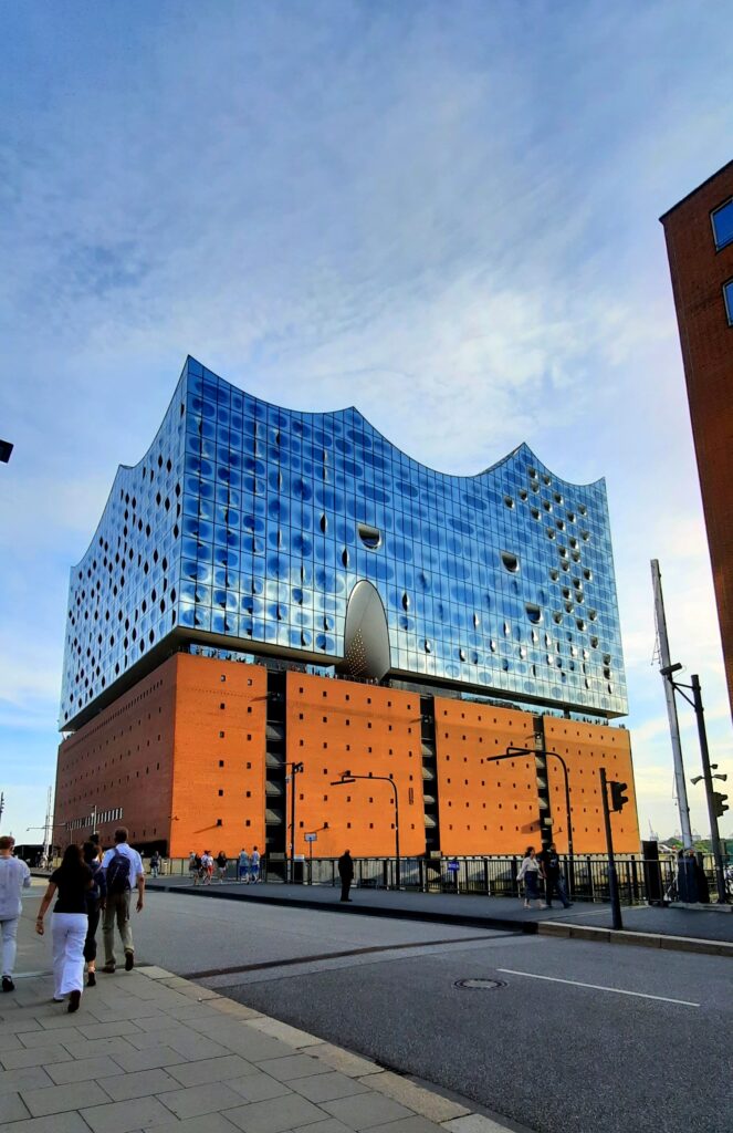 Elbphilharmonie concert hall in Hamburg, with its distinctive wave-shaped glass roof above the red-brick warehouse base.
