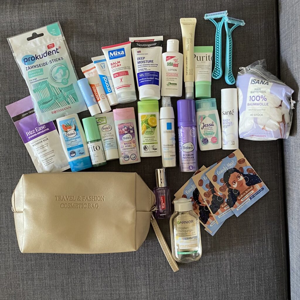 Travel-sized toiletries, skincare and beauty products laid out before a trip