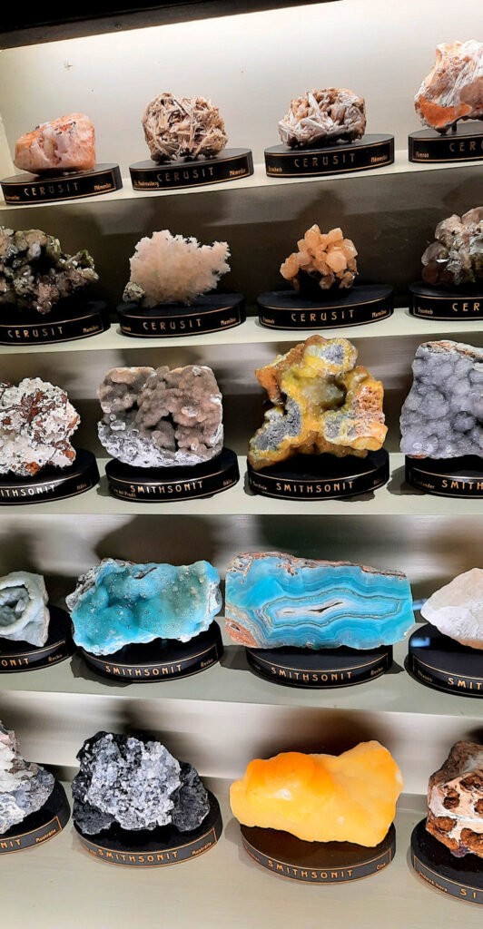Display of colourful minerals and crystals in glass cases at the National Museum in Prague.